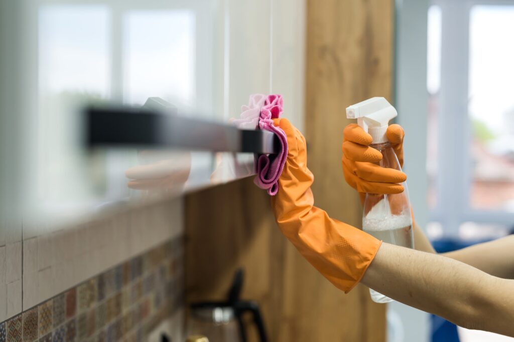 woman-rubber-gloves-cleaning-kitchen-counter-with-sponge-housework-min